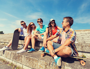 Image showing group of smiling friends sitting on city street