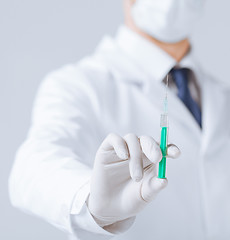 Image showing male doctor holding syringe with injection