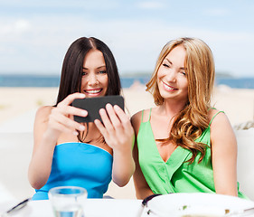 Image showing girls taking photo in cafe on the beach