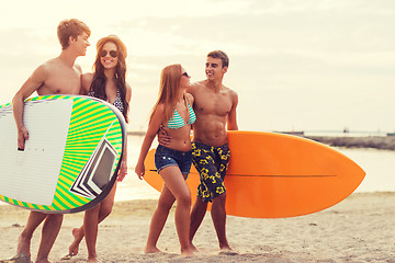 Image showing smiling friends in sunglasses with surfs on beach