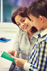 Image showing school boy with notebook and teacher in classroom