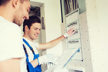 Image showing builders with clipboard and electrical panel