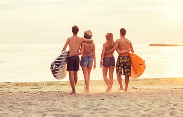 Image showing smiling friends in sunglasses with surfs on beach