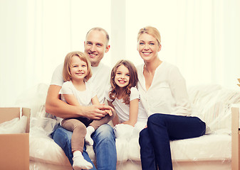 Image showing smiling parents and two little girls at new home