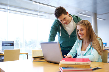 Image showing happy students with laptop in library