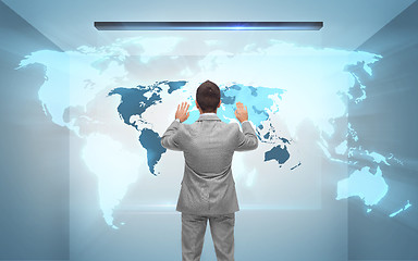 Image showing businessman working with hologram of world map