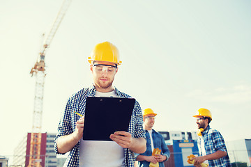 Image showing group of builders in hardhats outdoors