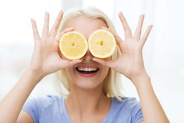 Image showing happy woman having fun covering eyes with lemon
