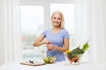 Image showing smiling woman cooking vegetable salad at home