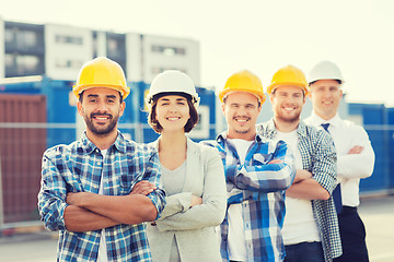 Image showing group of smiling builders in hardhats outdoors