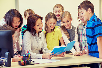 Image showing group of school kids with teacher in classroom