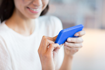 Image showing close up of woman with smartphone at cafe