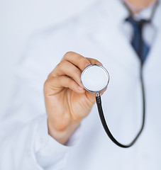 Image showing doctor hand with stethoscope listening something