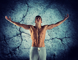 Image showing young male bodybuilder with raised hands