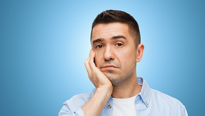 Image showing bored middle aged man face over blue background