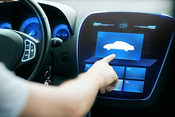 Image showing male hand pointing finger to car icon on panel