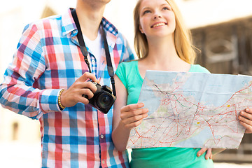 Image showing close up of couple with map and camera in city