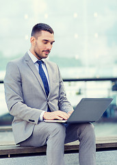 Image showing businessman working with laptop outdoors