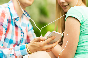 Image showing close up of couple with smartphone and earphones