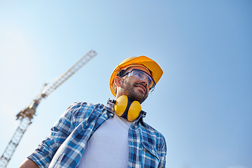 Image showing smiling builder with hardhat and headphones