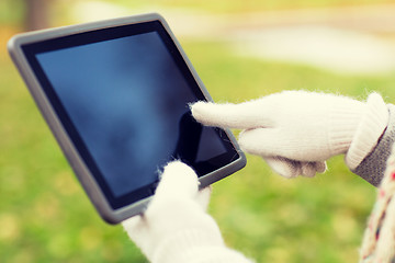 Image showing hands in autumn gloves holding tablet pc outdoors