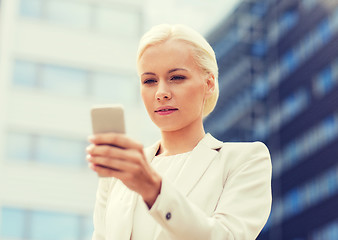 Image showing serious businesswoman with smartphone outdoors