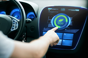 Image showing male hand setting car eco system mode on screen