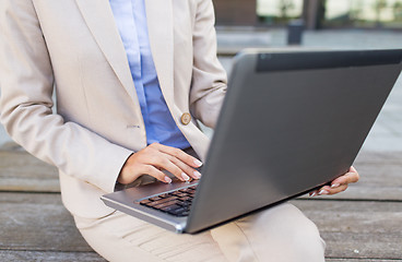 Image showing close up of business woman with laptop in city