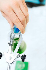 Image showing close up of scientist filling test tubes in lab