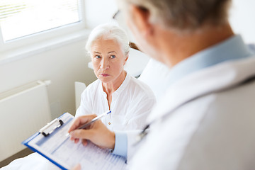 Image showing senior woman and doctor with clipboard at hospital