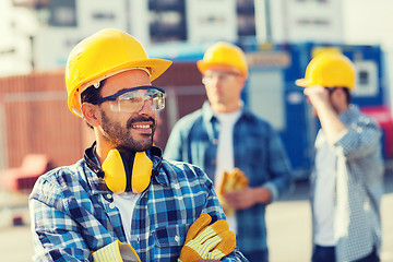 Image showing group of smiling builders in hardhats outdoors