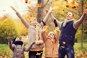 Image showing happy family playing with autumn leaves in park