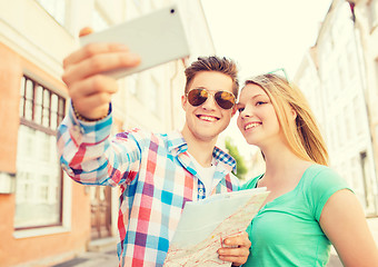 Image showing smiling couple with smartphone in city