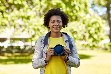 Image showing happy african woman with digital camera in park