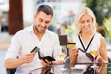 Image showing couple with credit cards paying bill at restaurant