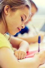 Image showing close up of school kids writing test in classroom