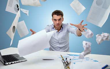 Image showing angry businessman throwing papers in office