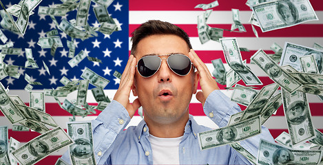 Image showing surprised man under money rain over american flag