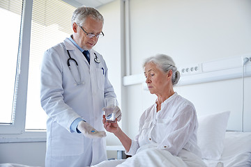 Image showing doctor giving medicine to senior woman at hospital