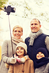 Image showing happy family with smartphone and monopod in park