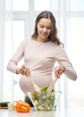 Image showing happy pregnant woman preparing food at home