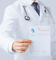 Image showing male doctor holding rx paper in hand