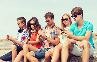 Image showing group of friends with smartphones outdoors