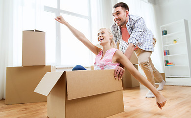 Image showing couple with cardboard boxes having fun at new home