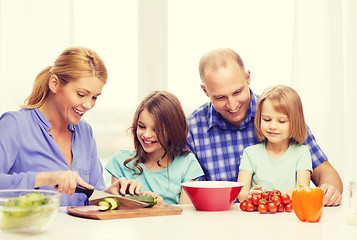 Image showing happy family with two kids making dinner at home