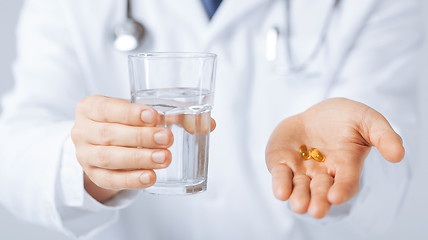 Image showing doctor hands giving capsule and glass of water