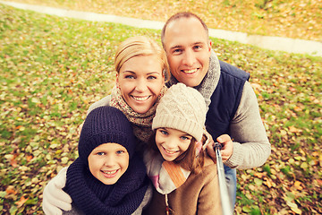 Image showing happy family with selfie stick in autumn park