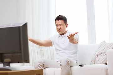 Image showing disappointed man watching tv at home