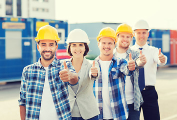 Image showing group of smiling builders in hardhats outdoors