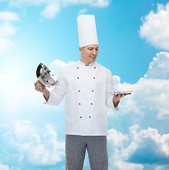 Image showing happy male chef cook opening cloche